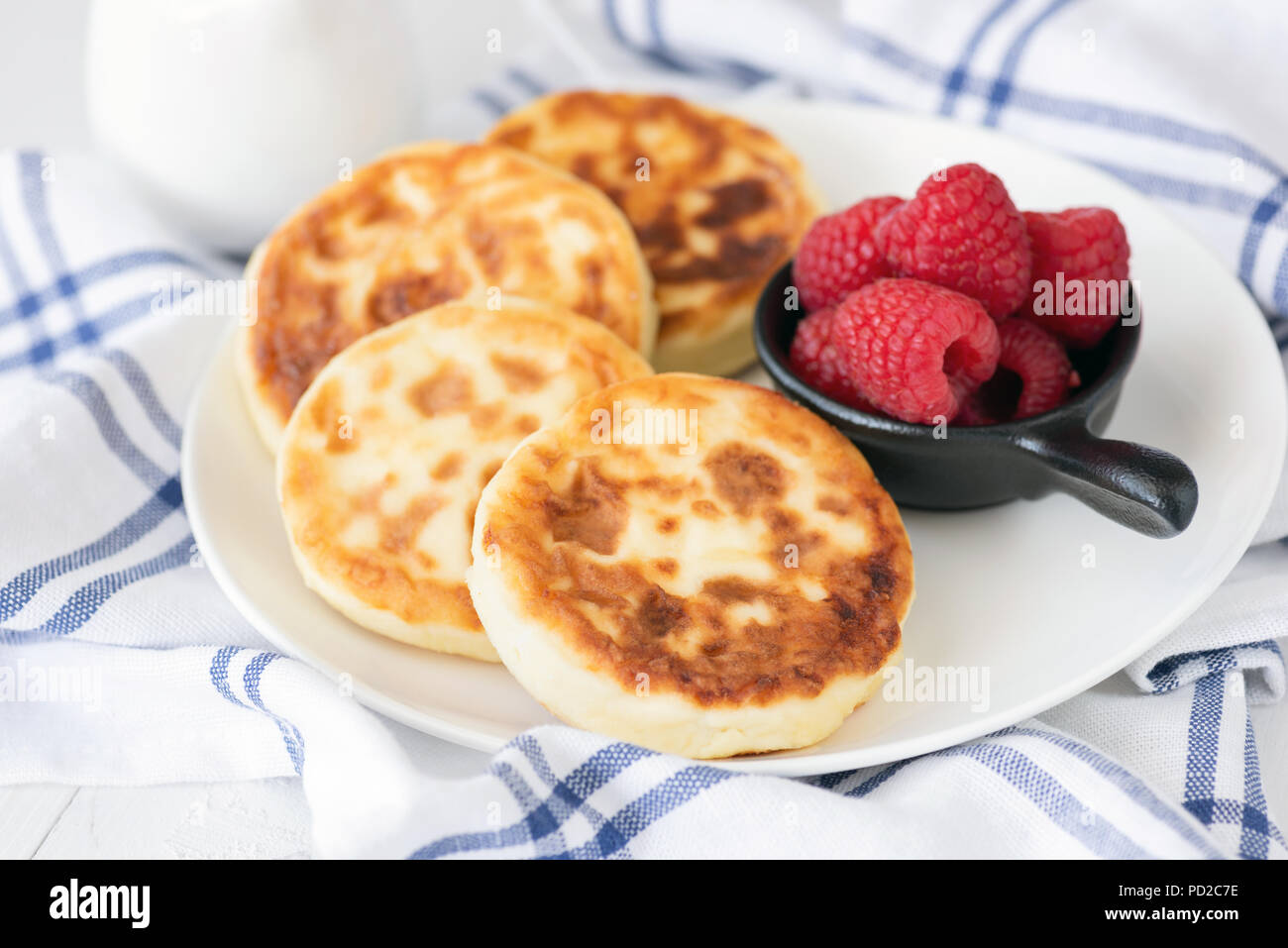 Quark Pfannkuchen auf weiße Platte. Auch als syrniki, sirniki oder Quark Krapfen bekannt. Russische Küche Stockfoto