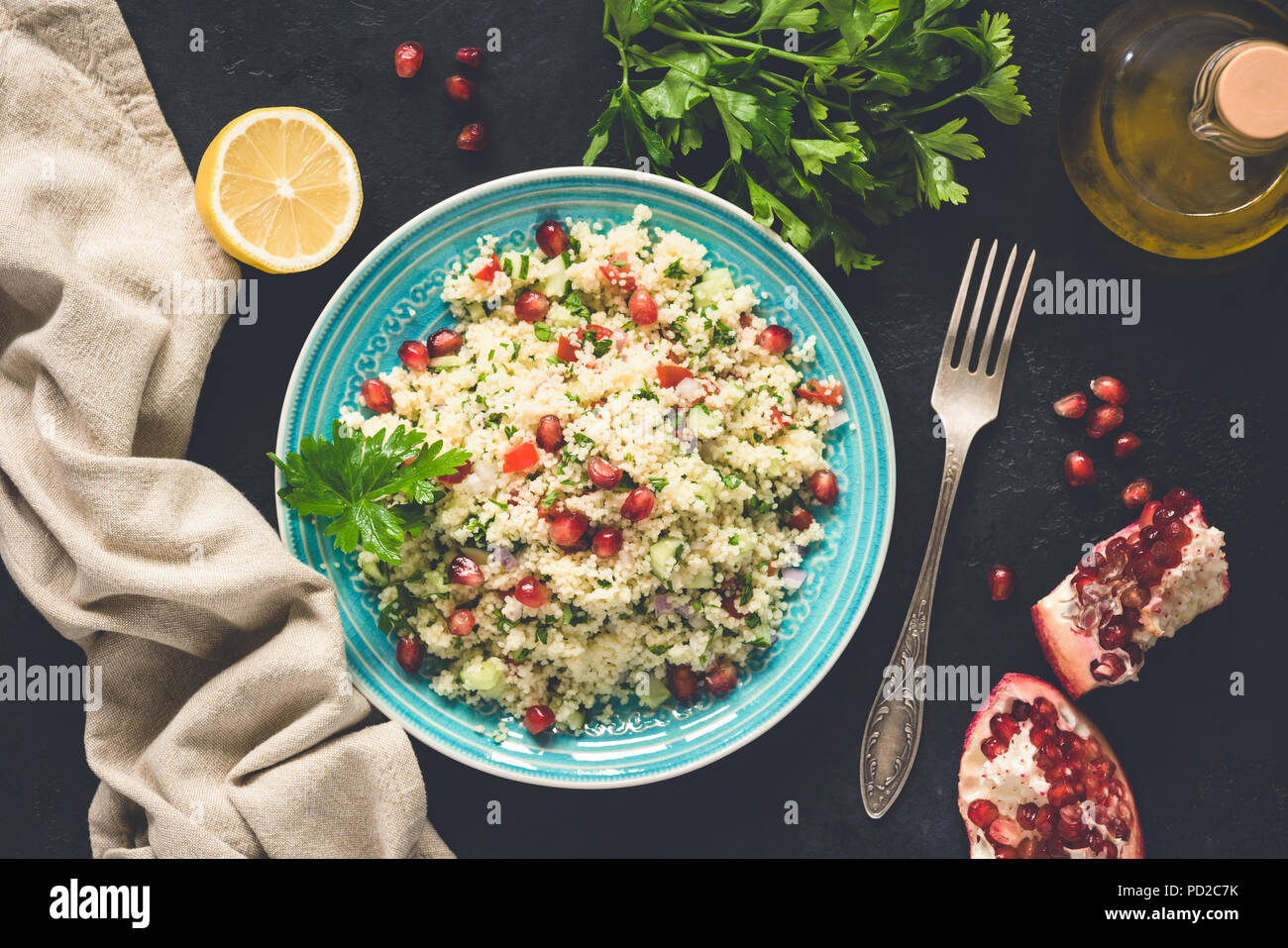 Im Nahen und Mittleren Osten Salat Tabbouleh mit CousCous, Granatapfel Samen, Petersilie. Ansicht von oben, getönten Bild Stockfoto