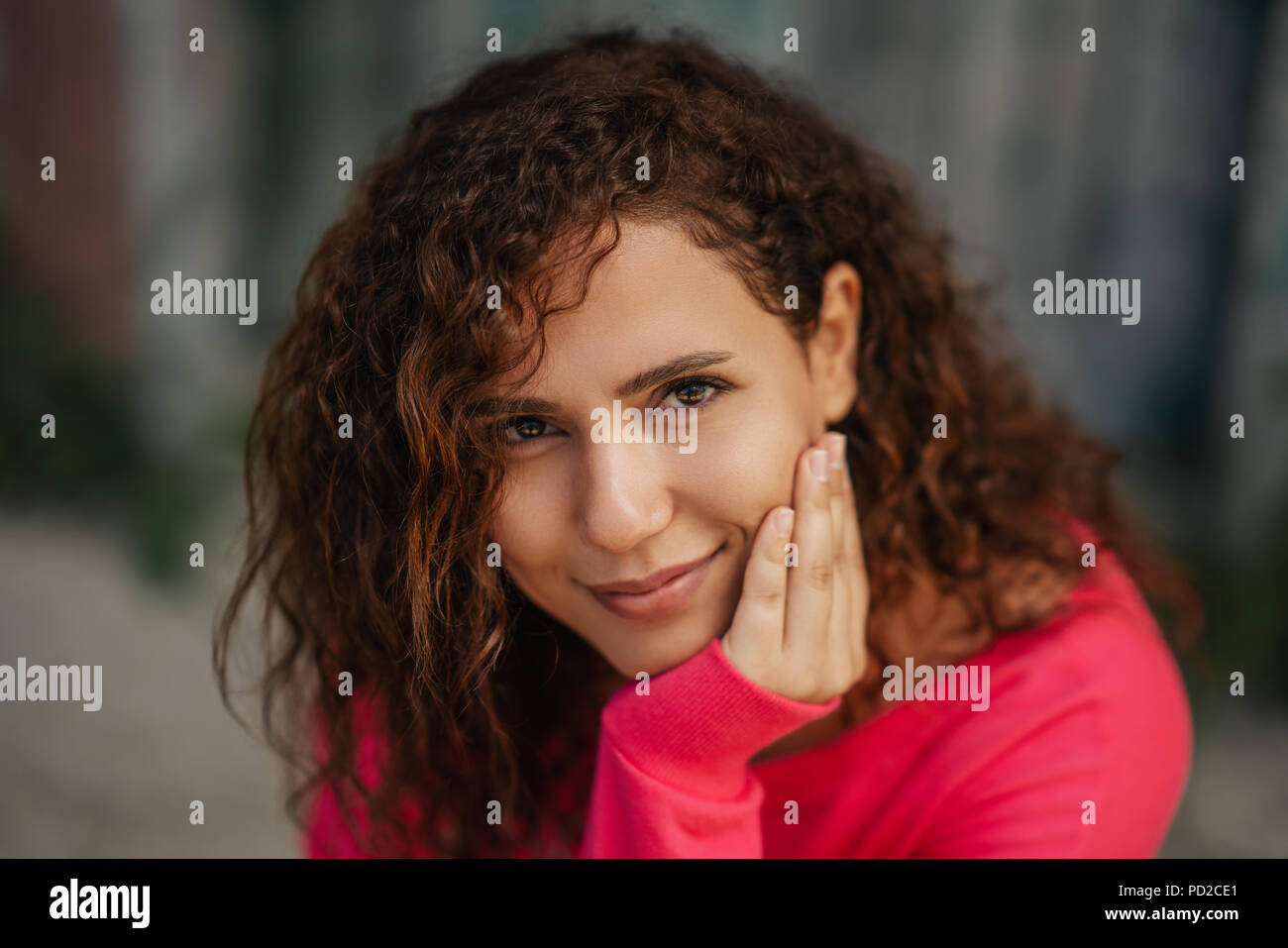 Nahaufnahme, Porträt einer fröhlichen lockige Junge Frau lächelnd im Freien. Stockfoto