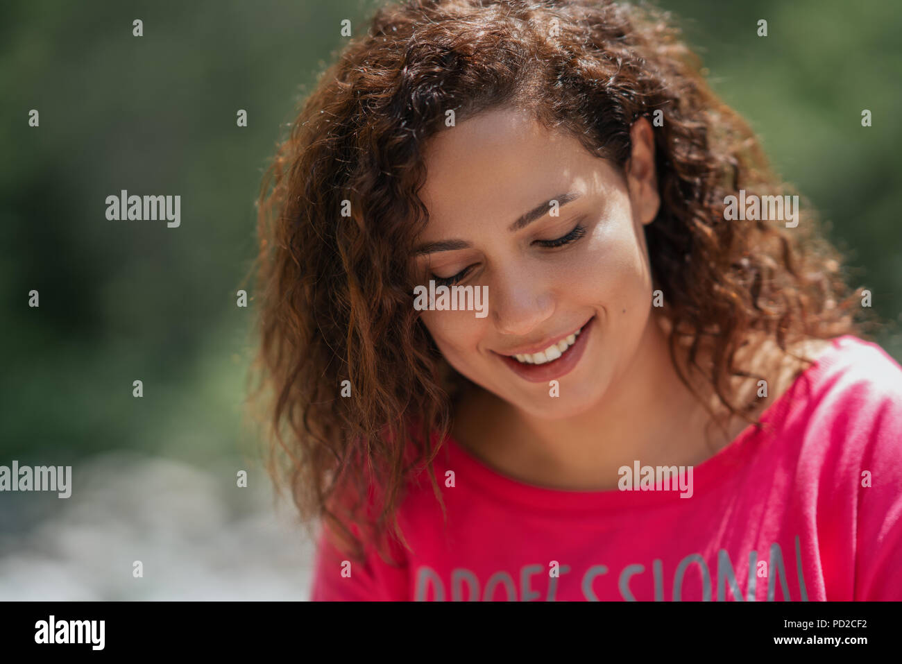 Nahaufnahme, Porträt einer fröhlichen lockige Junge Frau lächelnd im Freien. Stockfoto