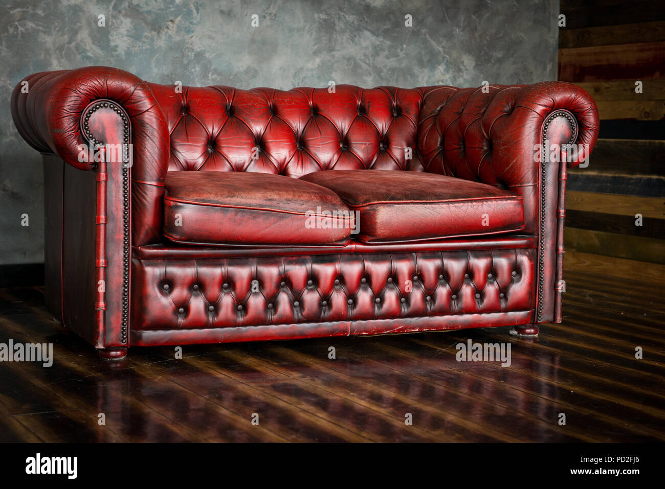 Das Sofa ist eine Ehre von Burgund Farbe im Innenraum. Stockfoto