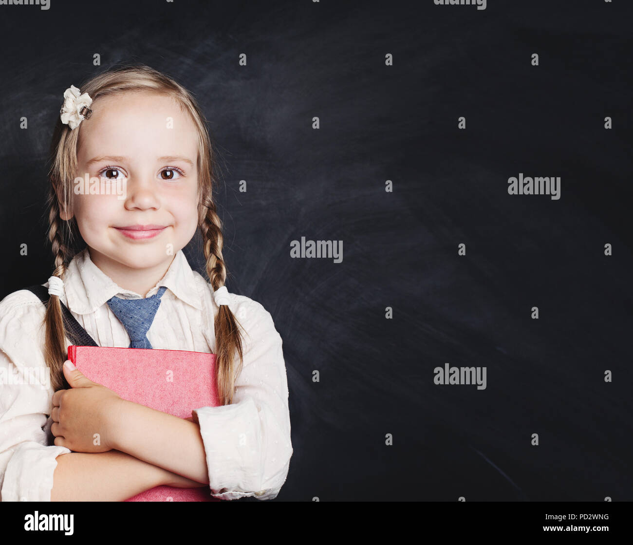 Lesen Buch und Bildung Konzept. Lächelnd kind Mädchen in Schuluniform auf schiefertafel Hintergrund. Zurück zur Schule Stockfoto