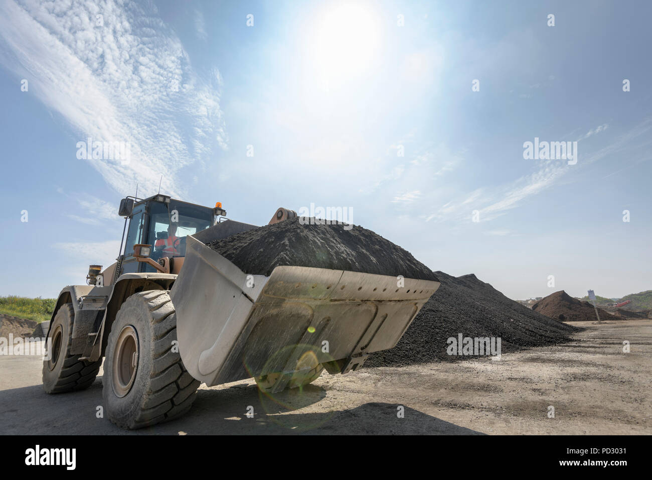 Digger mit großen Haufen von recycelten Boden in Beton recycling Site Stockfoto