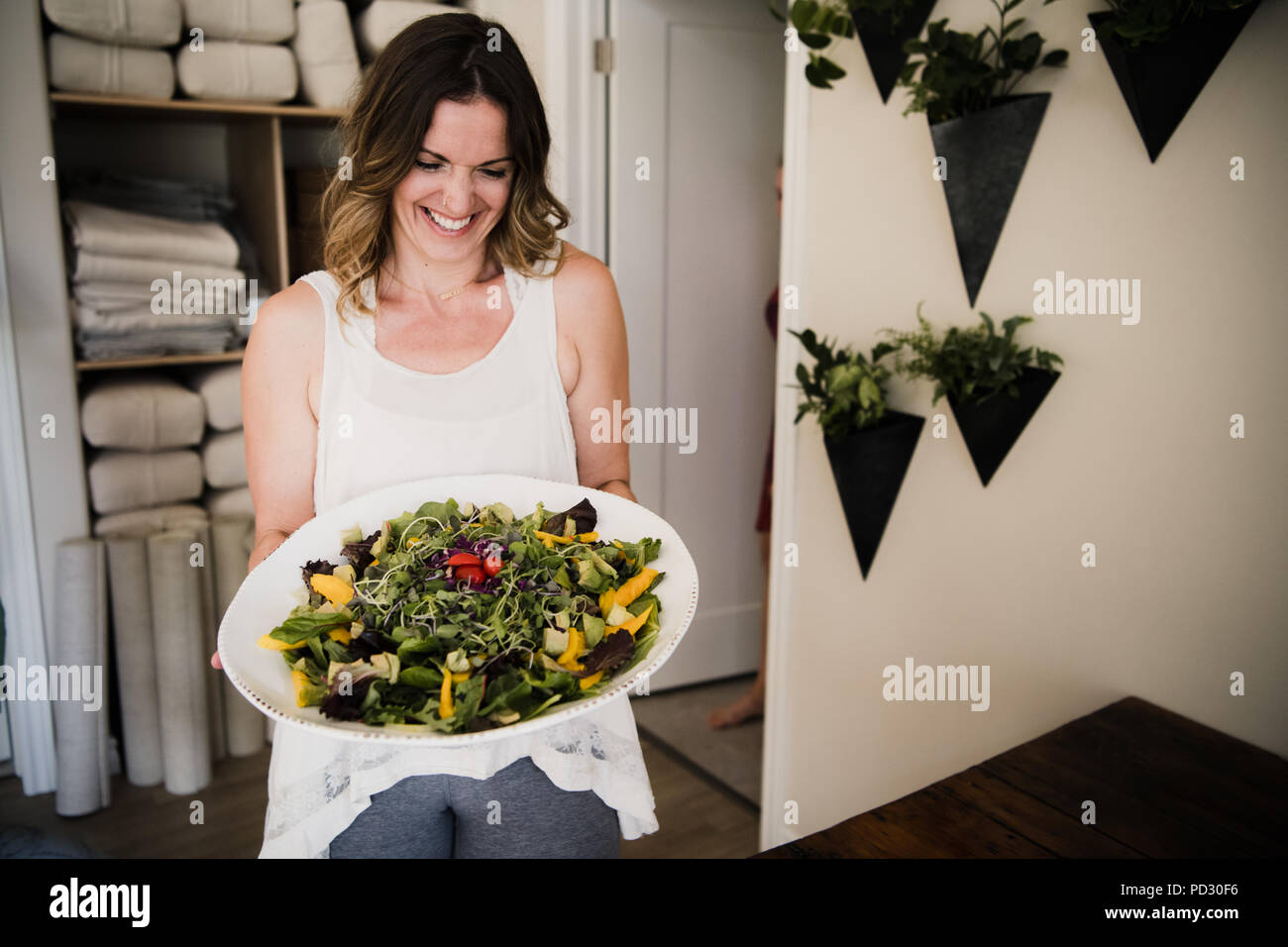 Frau große Schüssel Salat an Retreat Stockfoto
