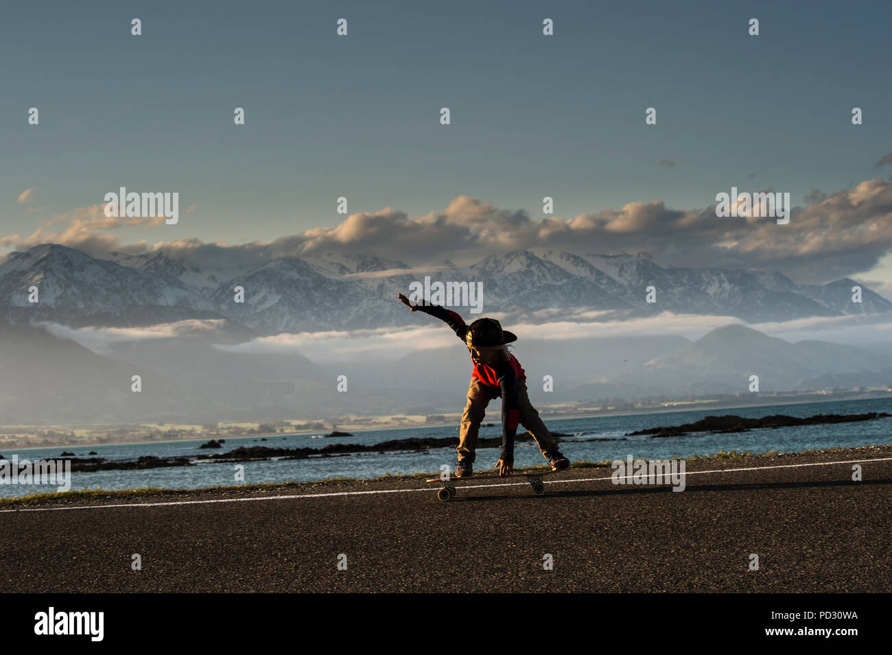 Junge skateboarding entlang der Küstenstraße, Kaikoura, Gisborne, Neuseeland Stockfoto