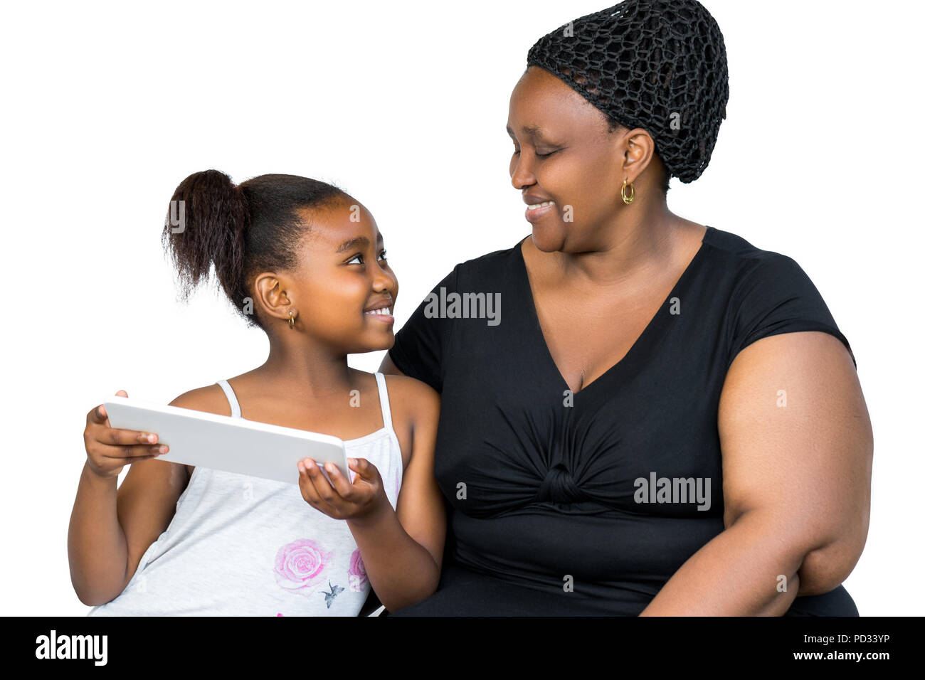 Nahaufnahme, Porträt eines kleinen afrikanischen Mädchens und Mutter Spaß zusammen mit digitalen Tablet auf weißem Hintergrund. Mutter und Tochter auf der Suche nach einem Stockfoto