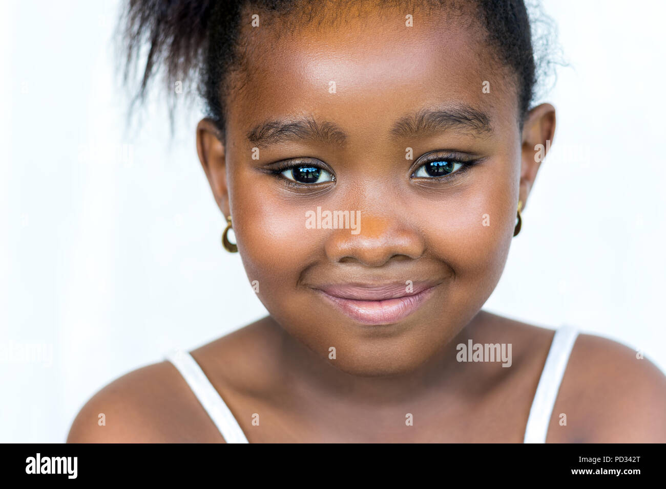 Nahaufnahme Gesicht schoss von niedlichen kleinen afrikanischen Mädchen mit Pferdeschwanz. auf weißem Hintergrund. Stockfoto