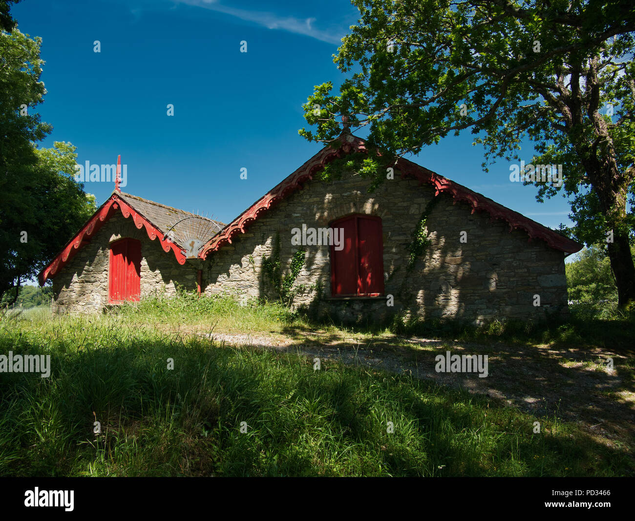 Zwei bootshäuser am See unter den Bäumen mit roten Balken an einem sonnigen Tag mit blauen Himmel Stockfoto Zwei bootshäuser am See unter den Bäumen mit roten Balken an einem sonnigen Tag mit blauen Himmel Stockfoto