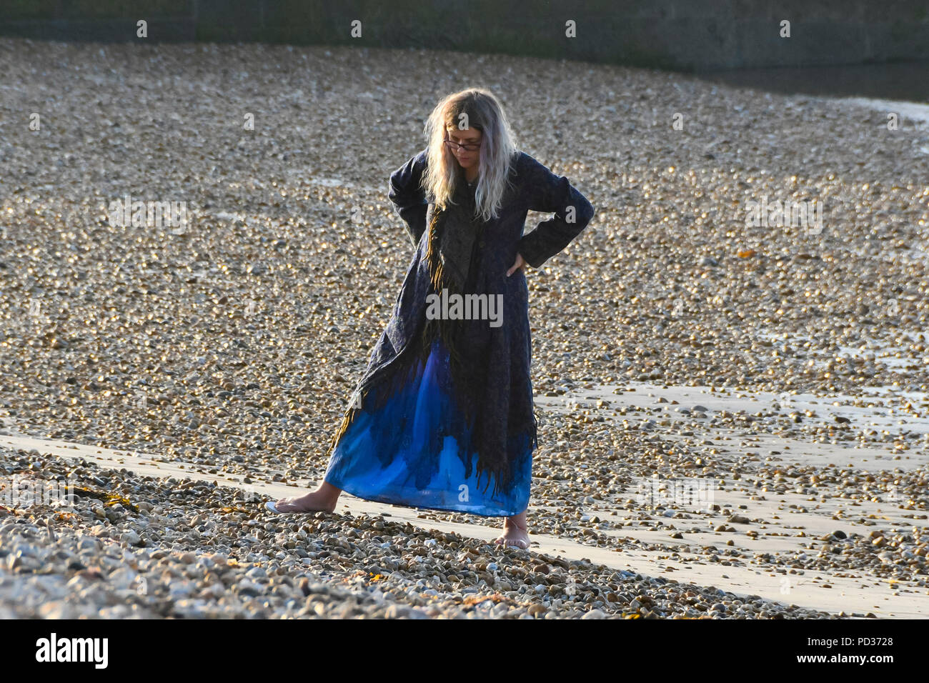 Lyme Regis, Dorset, Großbritannien. 6. August 2018. UK Wetter. Eine Frau am Strand die Sonne am frühen Morgen, bevor die Sonnenanbeter in Lyme Regis in Dorset kommen als die heißen Temperaturen eingestellt sind heute fortzusetzen. Foto: Graham Jagd-/Alamy leben Nachrichten Stockfoto