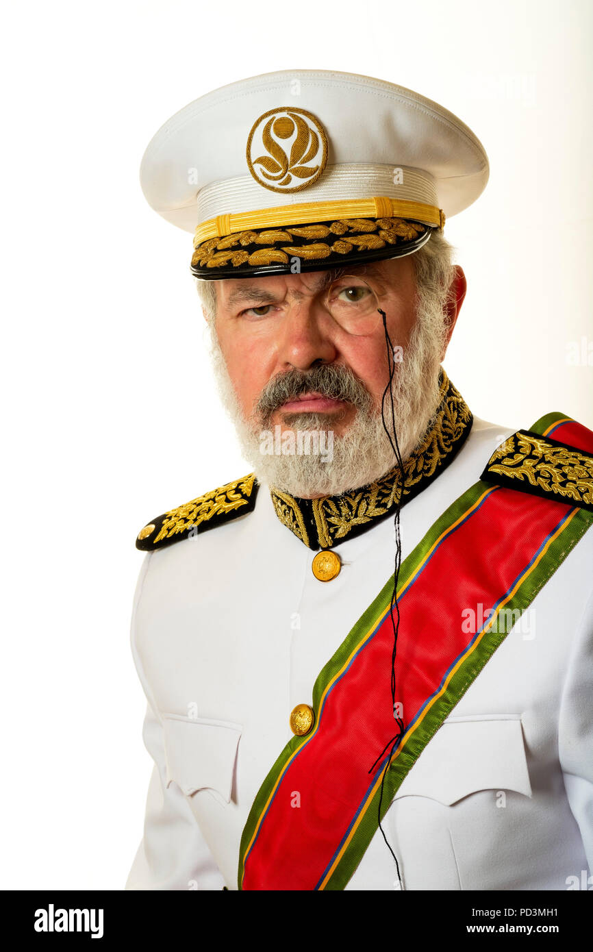 Fiktionale Charakter: Gouverneur Babala mit weißen volle Uniform, rot Anrede Schärpe und Monokel, Stockfoto