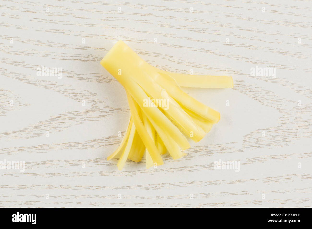 Ein Stück geräucherte slowakischen String Käse stick flatlay auf grau Holz Stockfoto