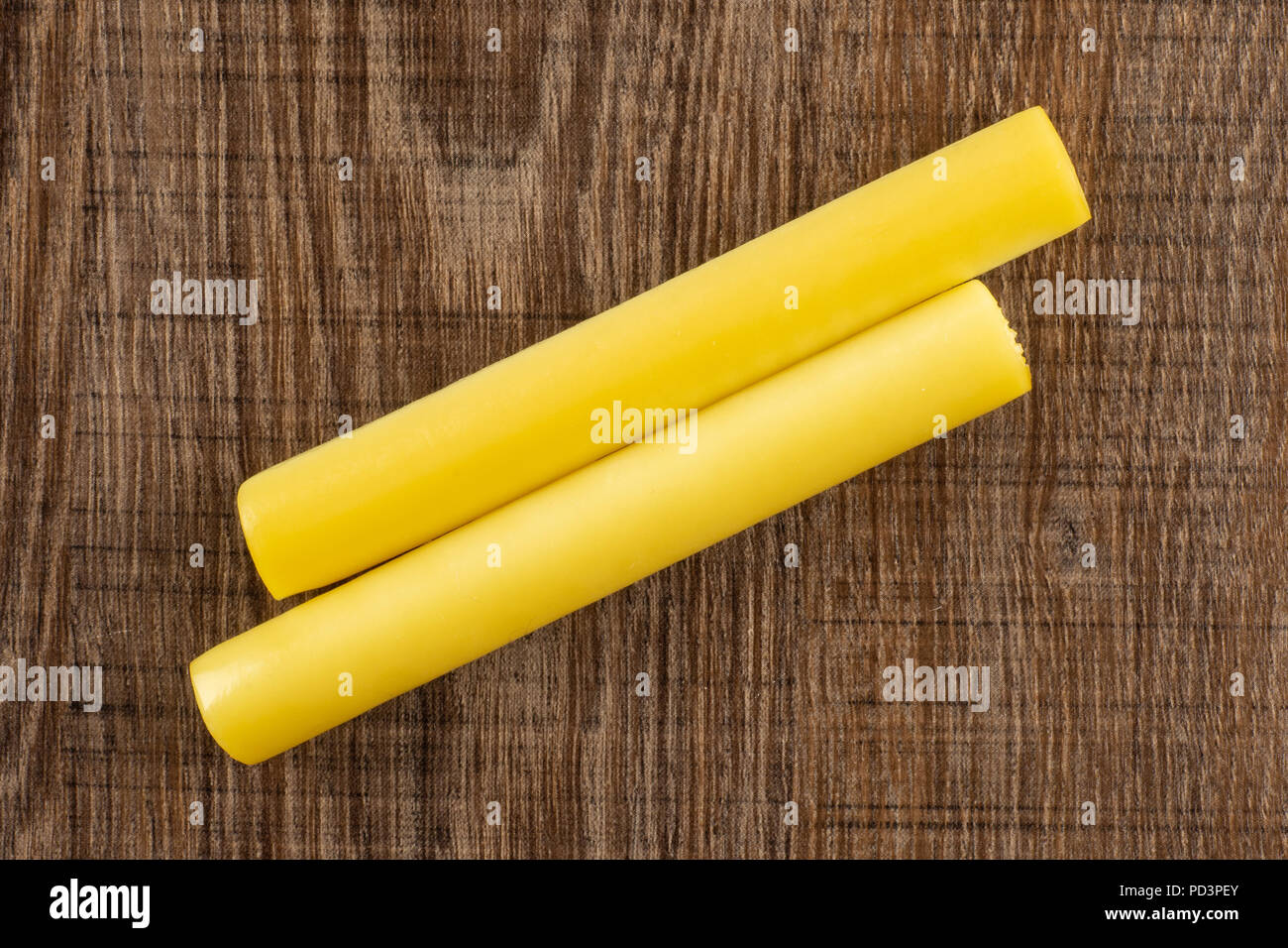 Gruppe von zwei Ganzen geräucherten slowakischen String Käse stick flatlay auf braunem Holz Stockfoto