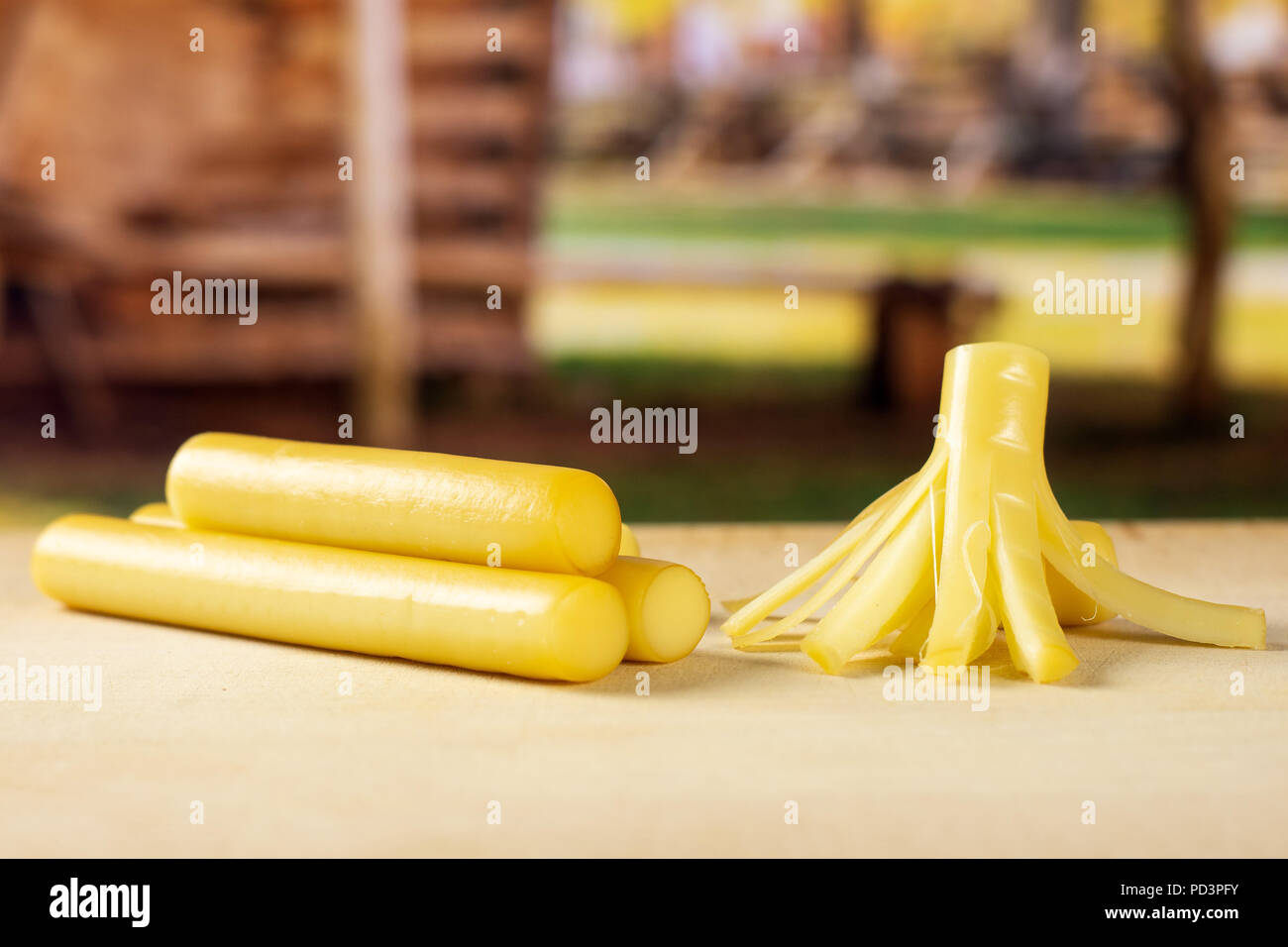 Gruppe von drei Ganzen ein Stück geräucherte slowakischen String Käse Stick mit Karre im Hintergrund Stockfoto