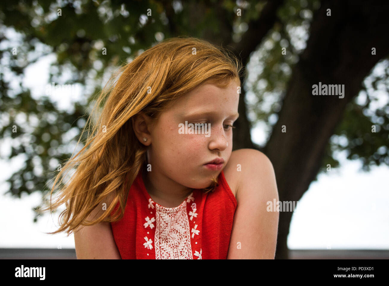 Mädchen puckering durch Baum Stockfoto