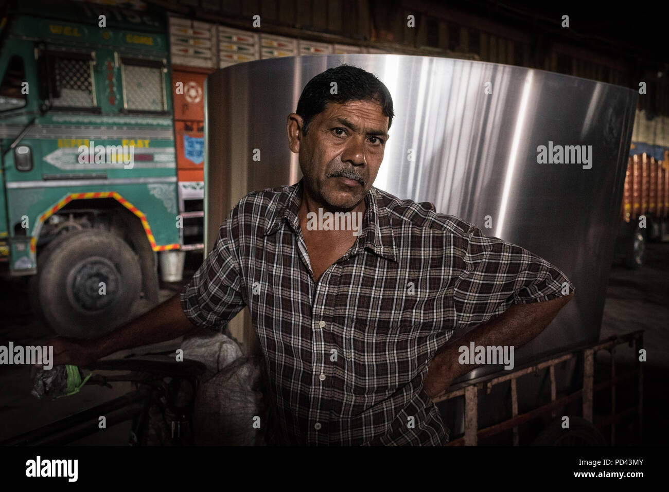 Porträt eines Treibers vor seinen Lkw in Kalkutta, Indien. Stockfoto