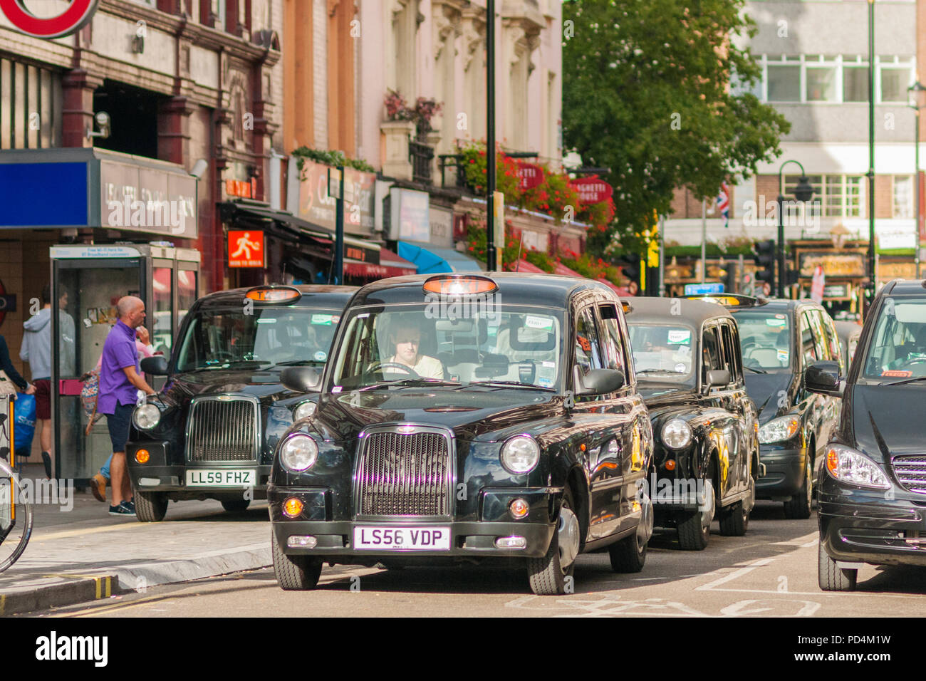LONDON, Großbritannien - 12 September 2012 Die schwarzen Taxis für grüne Signal an einer Ampel in der Nähe von Leicester Square in London warten. Stockfoto