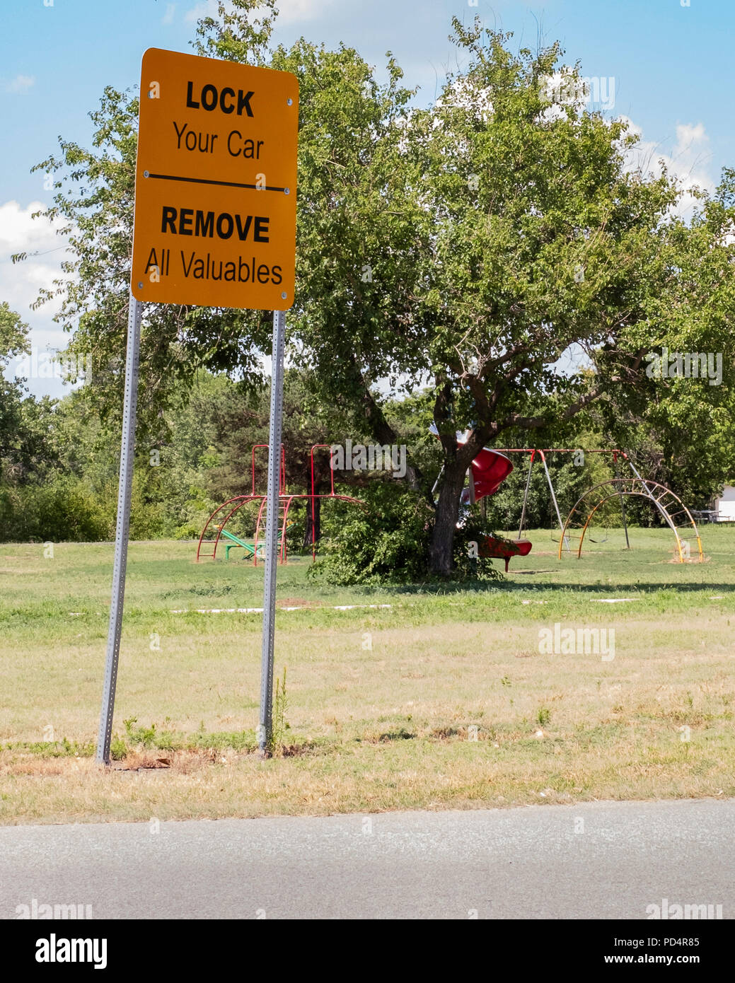 Ein Zeichen, Warnung der Bevölkerung, ihre Autos zu sperren und Wertsachen in einem öffentlichen Park in Wichita, Kansas, USA entfernen. Stockfoto