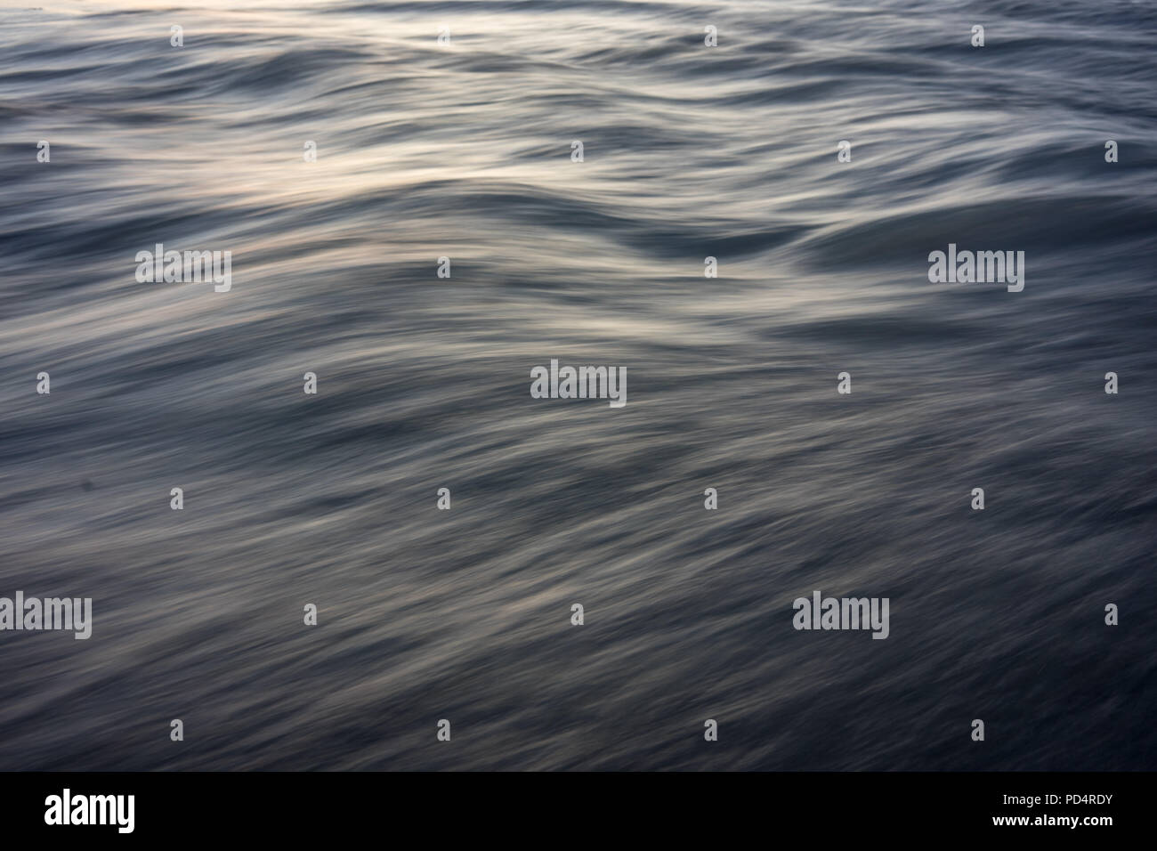 Lebendige Wasser Textur oder Struktur mit kleinen Wellen und Sonnenlicht Stockfoto
