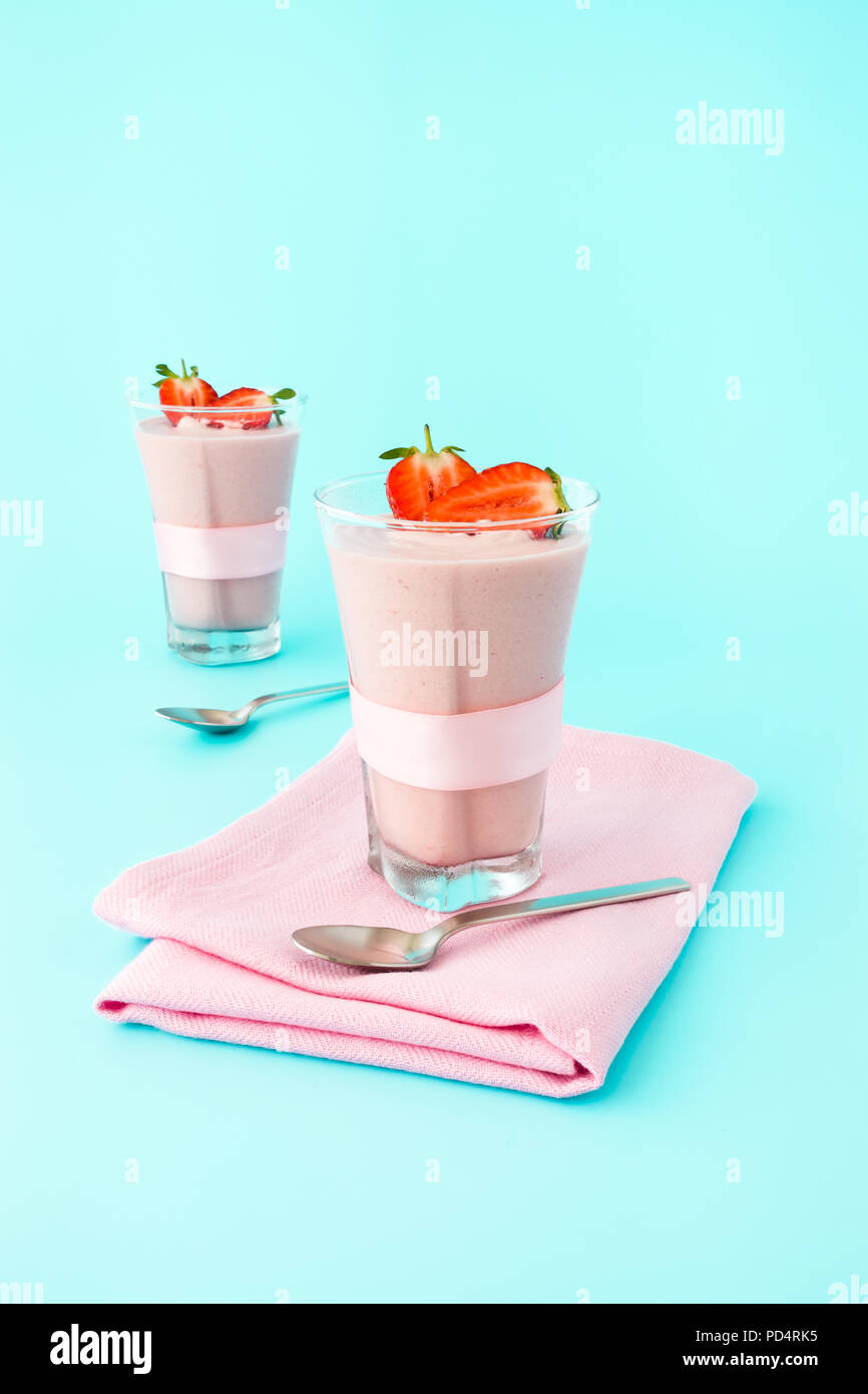 Zwei highball Gläser mit hausgemachten Erdbeer Mousse gefüllt auf hellblauem Hintergrund mit kopieren. Stockfoto