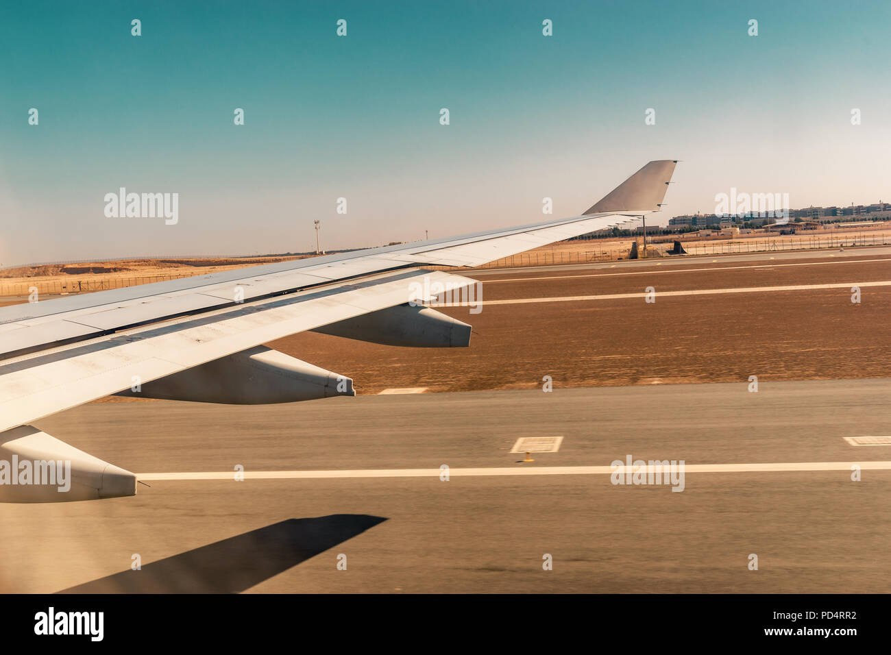 Luftaufnahme aus dem Flugzeugfenster beim Abheben von der Startbahn des Flughafens mit Wüste und blauer Himmel Stockfoto
