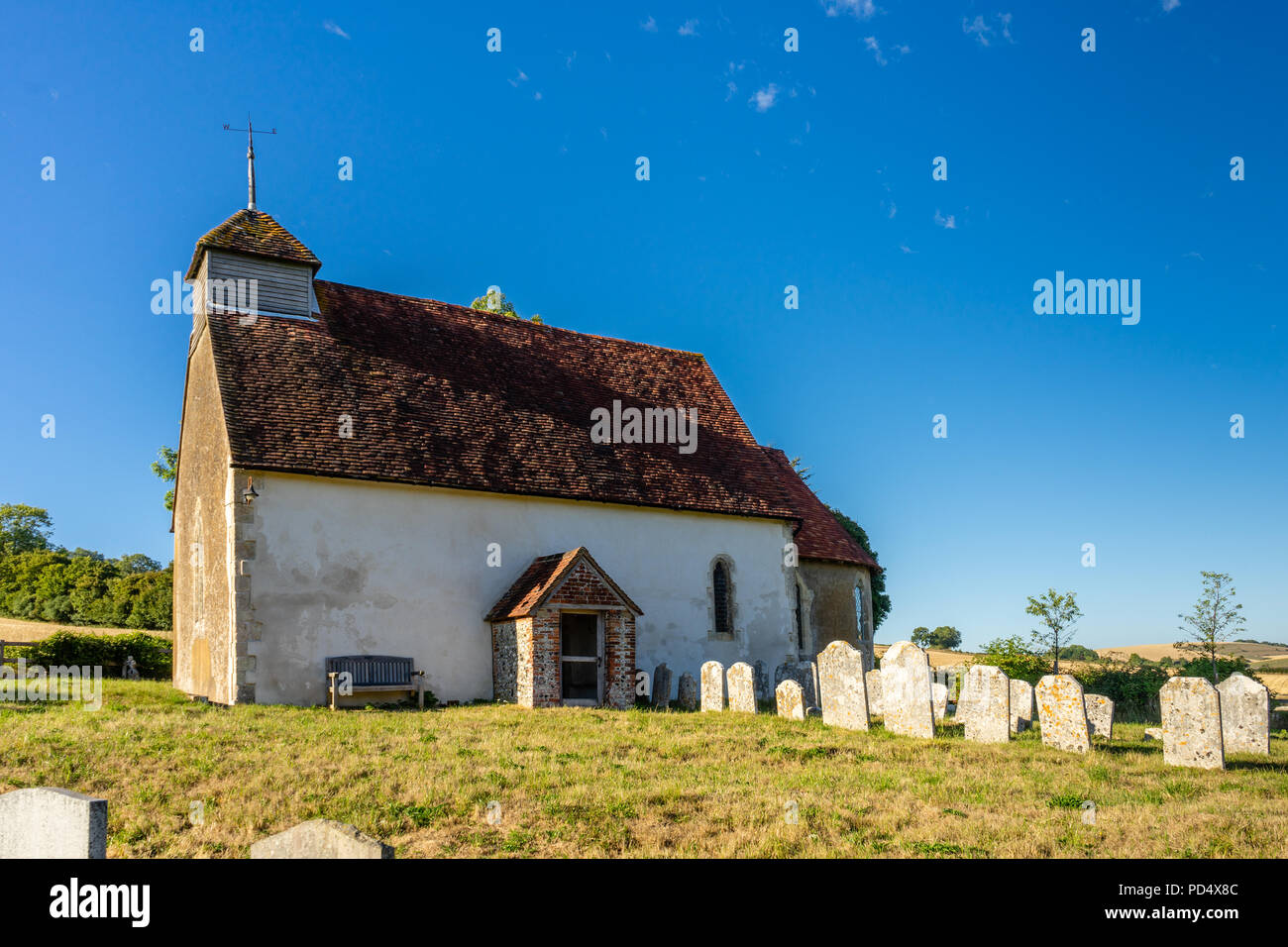 Marienkirche in Upwaltham - eine kleine Kirche aus dem 12. Jahrhundert in Upwaltham durch Landschaft und blauer Himmel, Upwaltham, West Sussex, England, Großbritannien Stockfoto