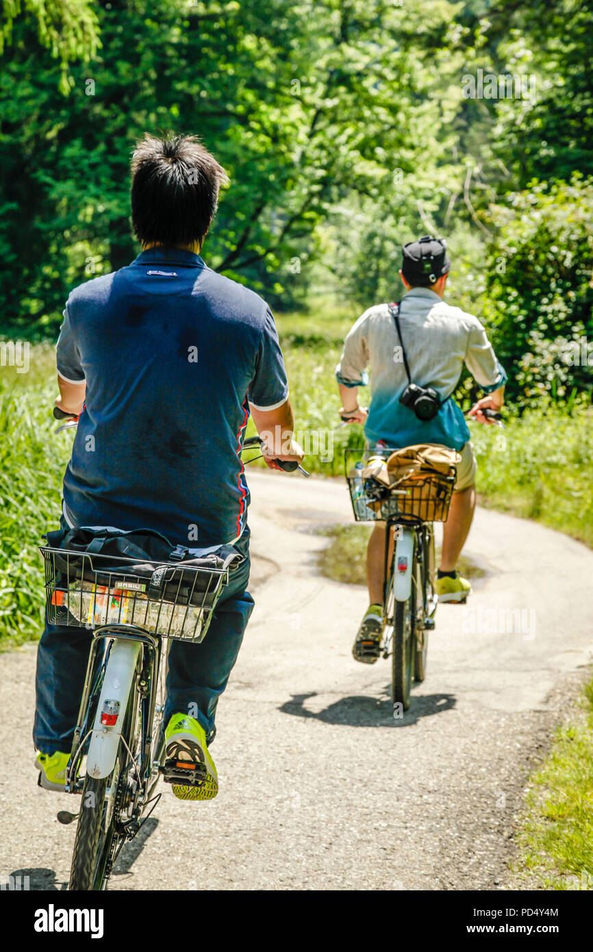 Die Menschen genießen Sie eine gemütliche Fahrt mit dem Fahrrad im ländlichen Österreich an einem Sommertag. Stockfoto