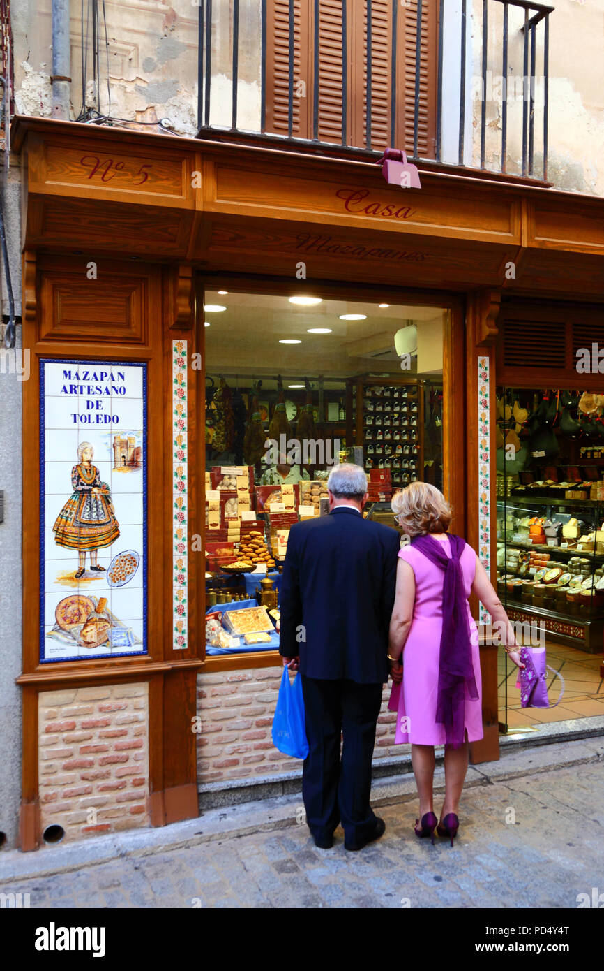 Gut gekleideter Ehemann und Ehefrau schauen durch das Schaufenster des Ladens und verkaufen das berühmte lokale Marzipan, Toledo, Kastilien-La Mancha, Spanien Stockfoto