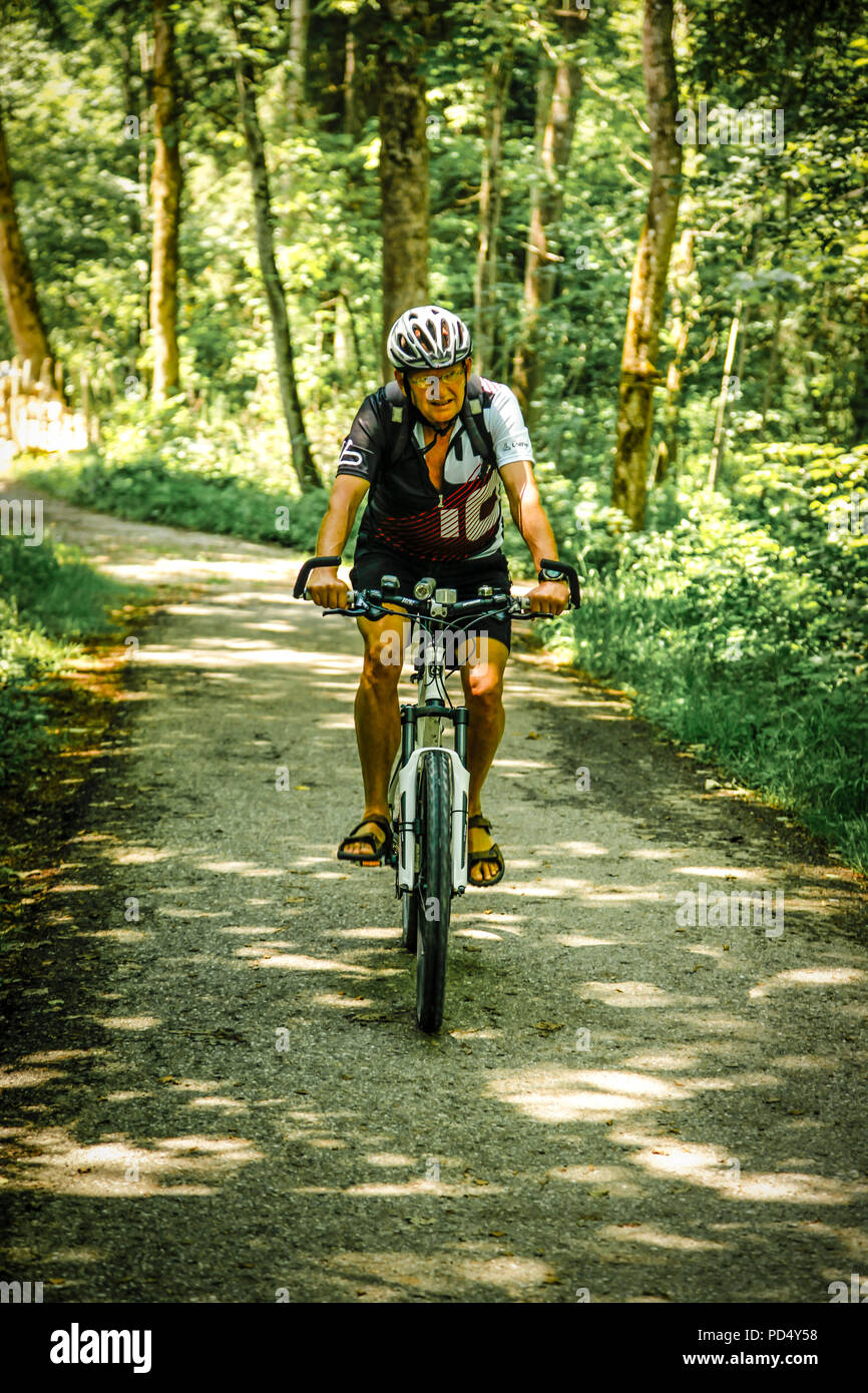 Die Menschen genießen Sie eine gemütliche Fahrt mit dem Fahrrad im ländlichen Österreich an einem Sommertag. Stockfoto