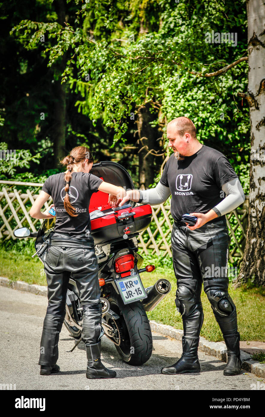 Motorradfahrer und sein Sozius stop am Straßenrand ein Picknick in den österreichischen Alpen zu genießen Stockfoto