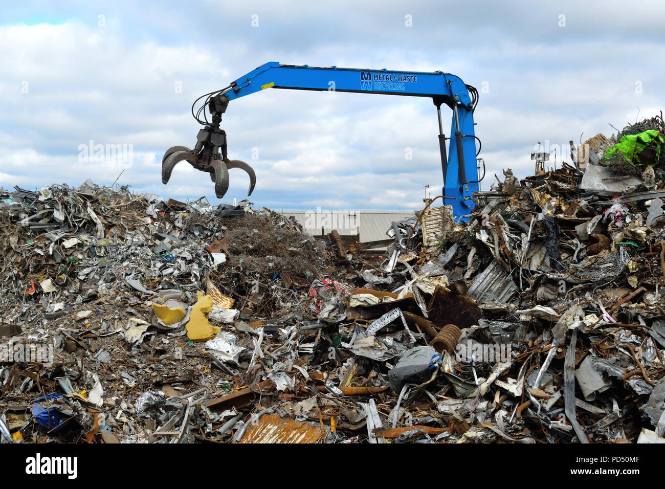 Aushub Maschine mit großen Kralle an der Altmetall Recycling Standort in Edmonton Industrial Estate, London auseinander. Stockfoto