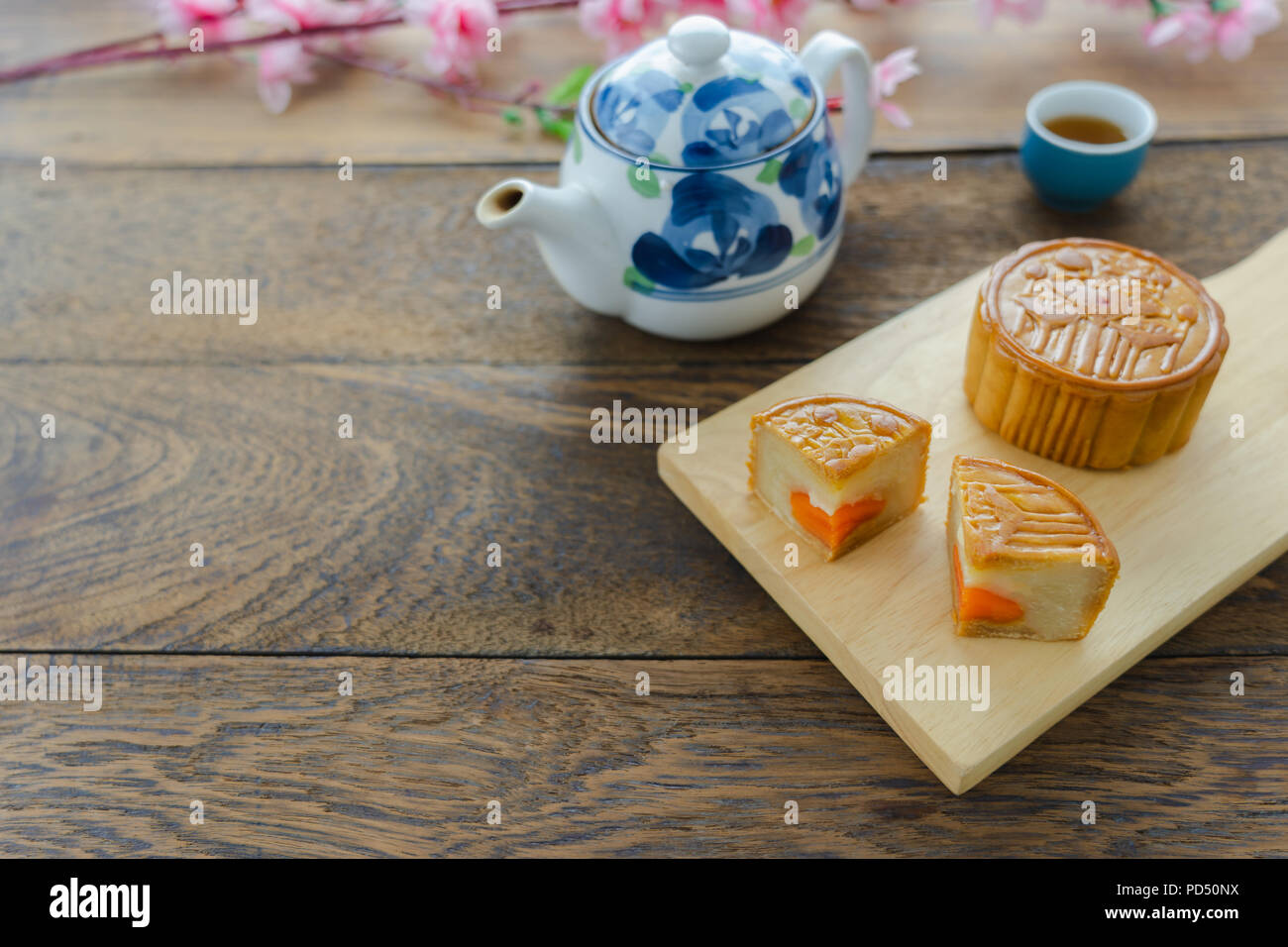 Schließen Sie herauf Bild von essen Dessert Dekorationen chinesische Mondfest Hintergrund Konzept. Essen & Trinken den Kuchen mit Kaffee Tasse und rosa Blüte auf modernen Rost Stockfoto