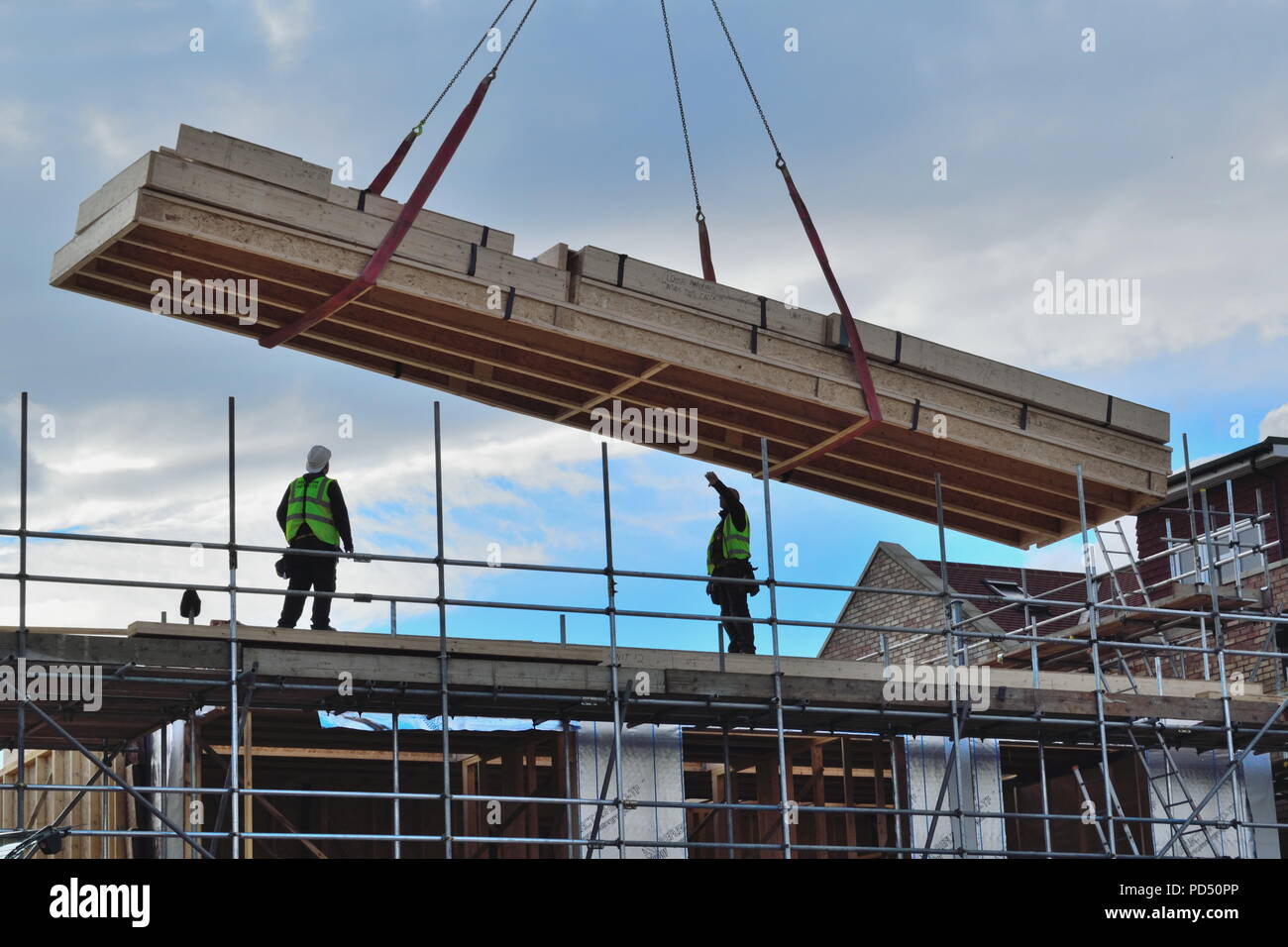 Silhouetten von Bauarbeitern auf der Oberseite des neuen Entwicklung mit großen Holz Lieferung Stockfoto