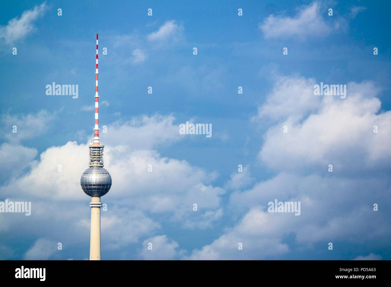 Panoramaaufnahme des Berliner Fernsehturms mit Wolken und blauem Himmel, Wahrzeichen der Stadt und Touristenattraktion am Alexanderplatz, Deutschland. Stockfoto