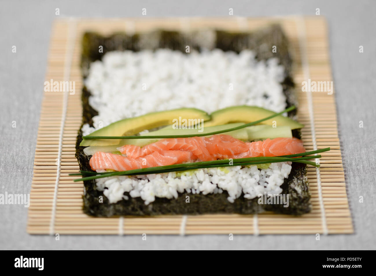 Rolling vorbereiten Maki shshi Rolle mit Lachs Stockfoto