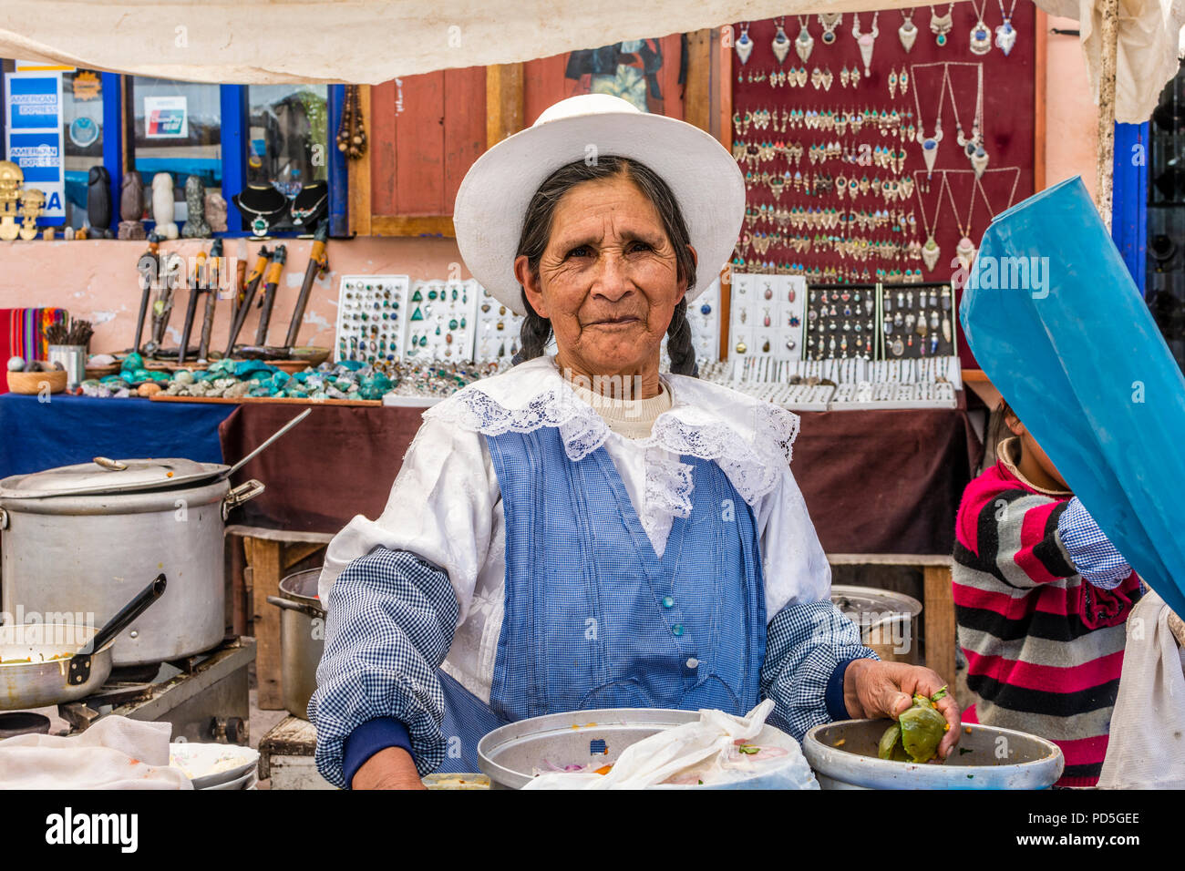 Lokale Reife der peruanischen Frau mit Zöpfen und Hut, bereitet das Essen in den lokalen Markt in Pisac, Peru, Südamerika. Stockfoto