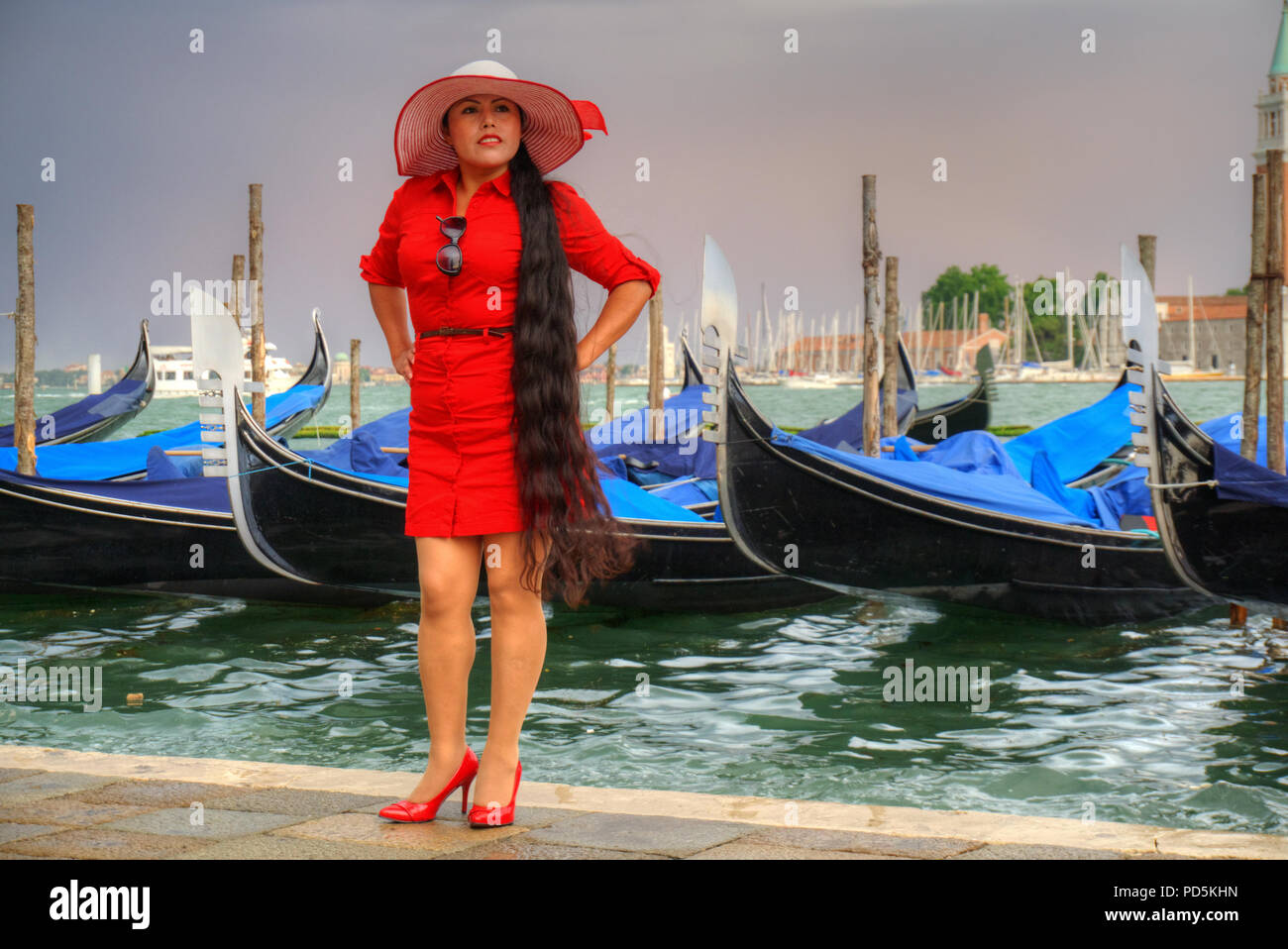 Dame in Rot Storming Venedig Stockfoto