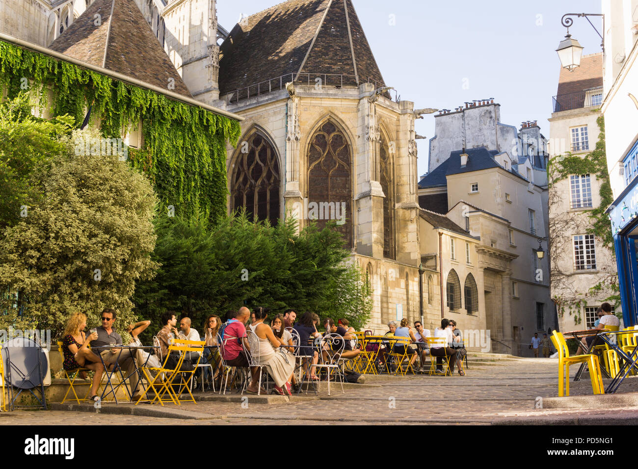 Café Paris Marais street scene - Menschen plaudern in einem Café in der Rue des Barres im Schatten der Kirche Saint Gervais in Frankreich Paris, Frankreich, Europa. Stockfoto