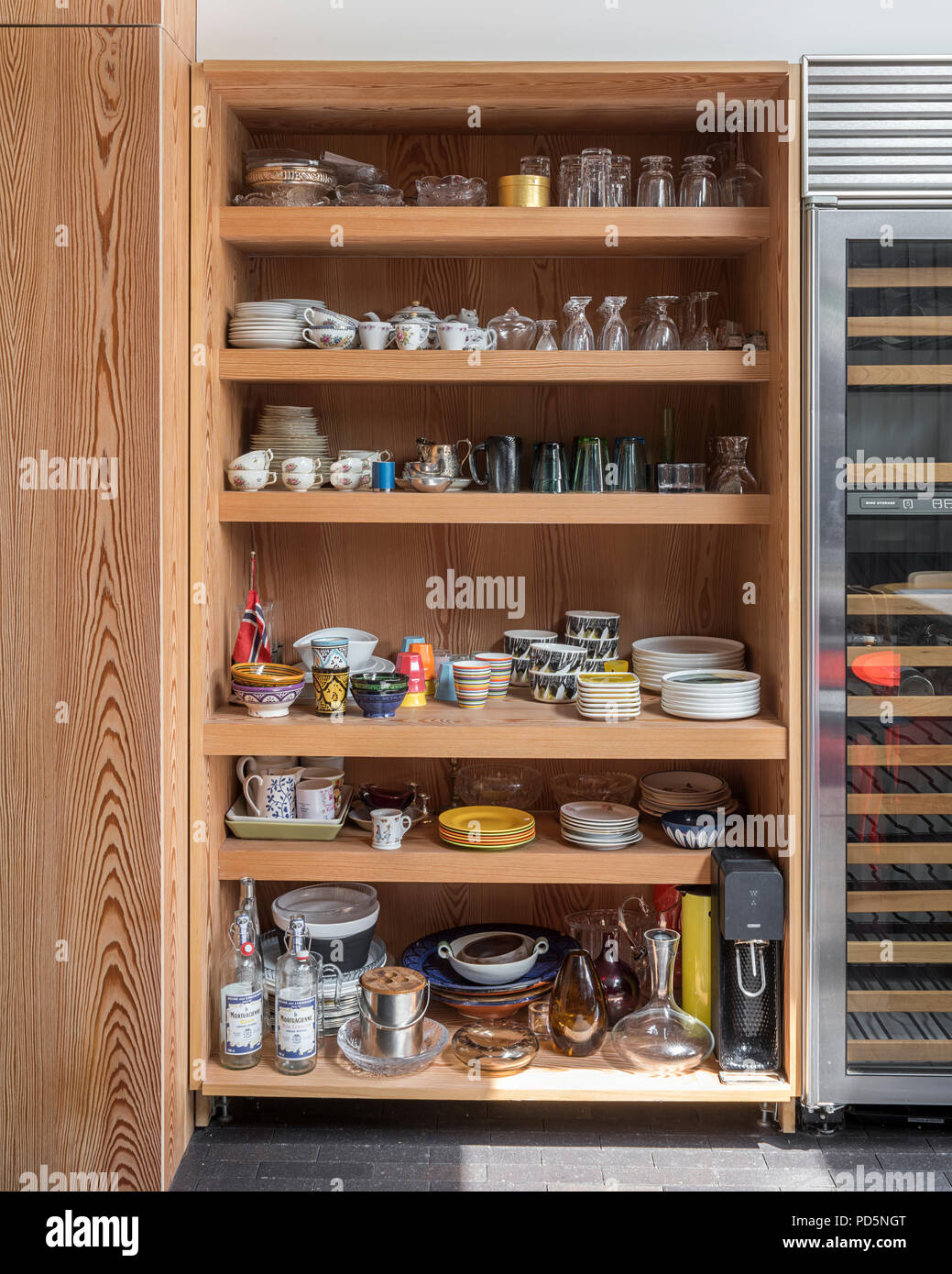 Offene Regale in der Küche voller Geschirr und Glaswaren Stockfoto