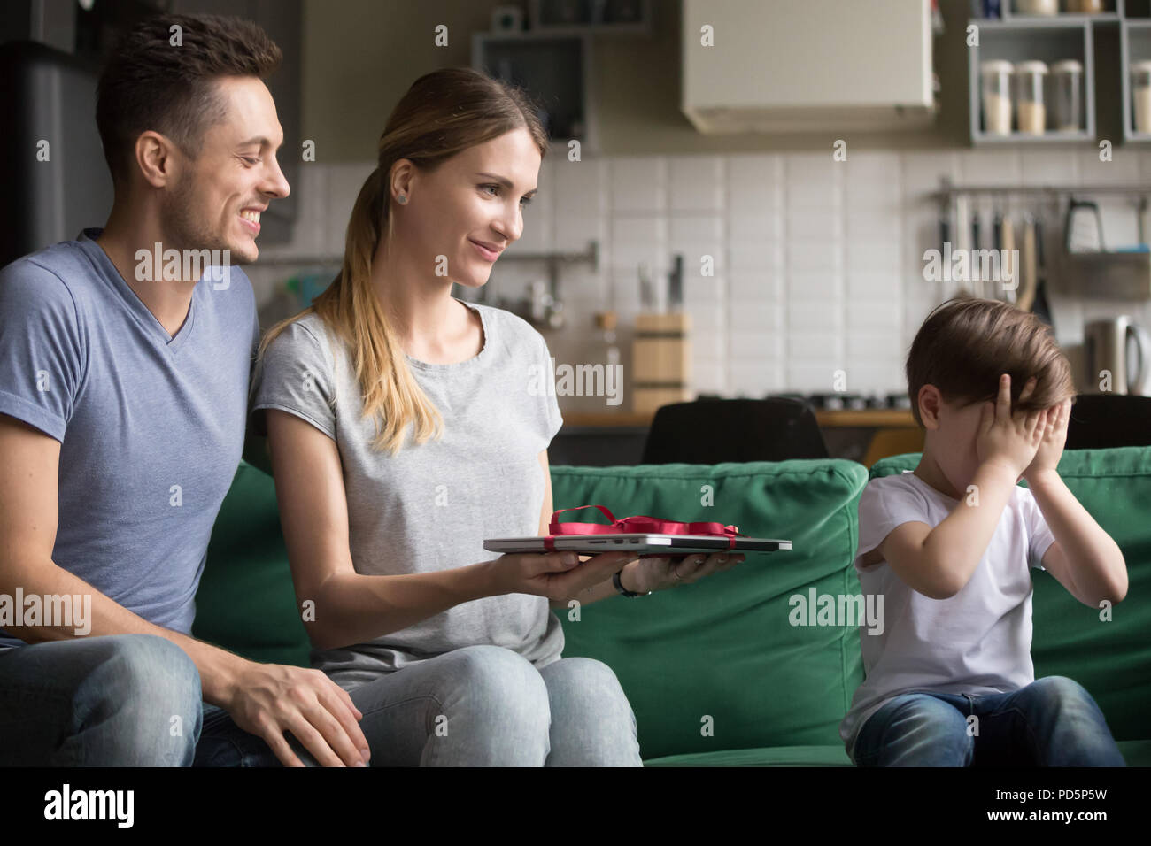 Kind Junge schließen Augen warten auf geburtstagsüberraschung von übergeordneten Stockfoto