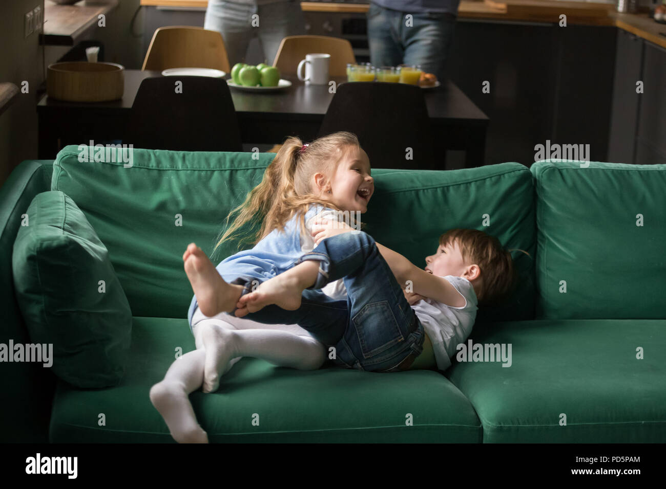 Kinder Schwester und Bruder lachen Kitzeln auf dem Sofa spielen bereitgestellt Stockfoto