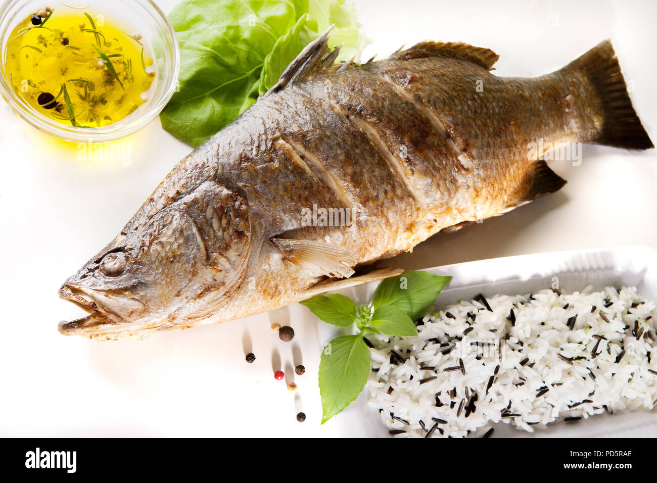 Fisch Baramundi Grill und wilder Reis auf weißem Hintergrund Stockfoto