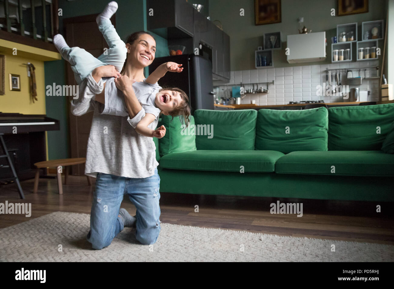 Glückliche Mutter oder Babysitter spielen mit Kind Mädchen zu Hause Stockfoto