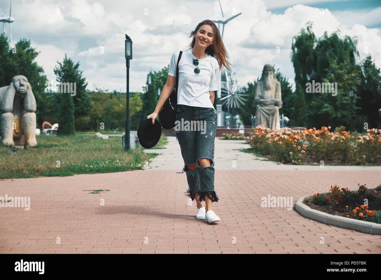 Lächelnde Frau Reisenden mit einem Rucksack auf dem Rücken zu Fuß Stockfoto