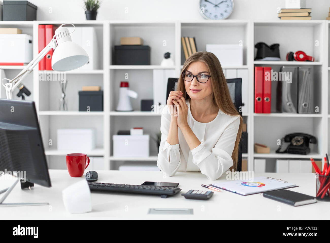 Ein junges Mädchen sitzt am Computer Schreibtisch im Büro. Stockfoto