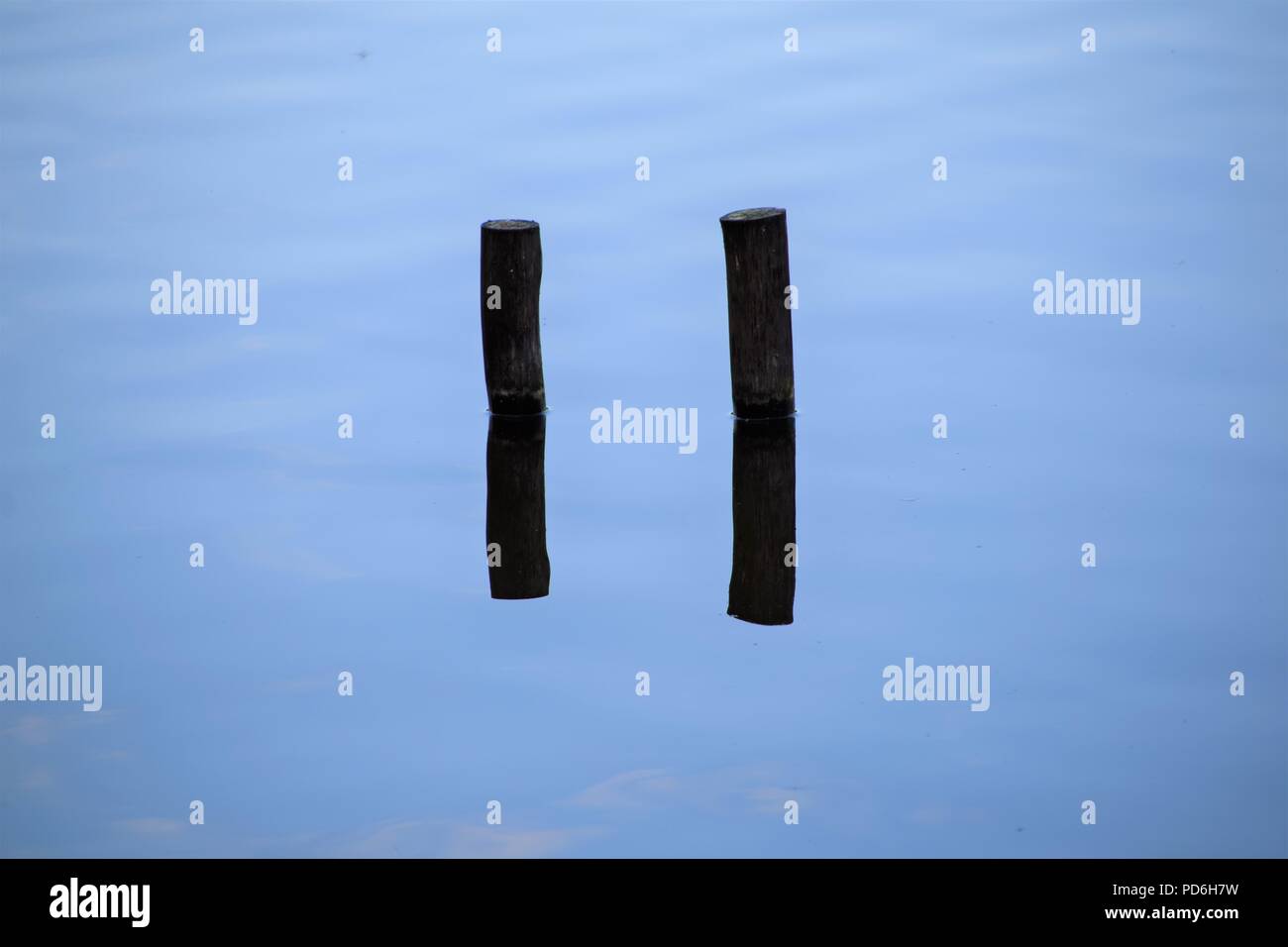 Reflexion von zwei Holz Sticks im Wasser Stockfoto