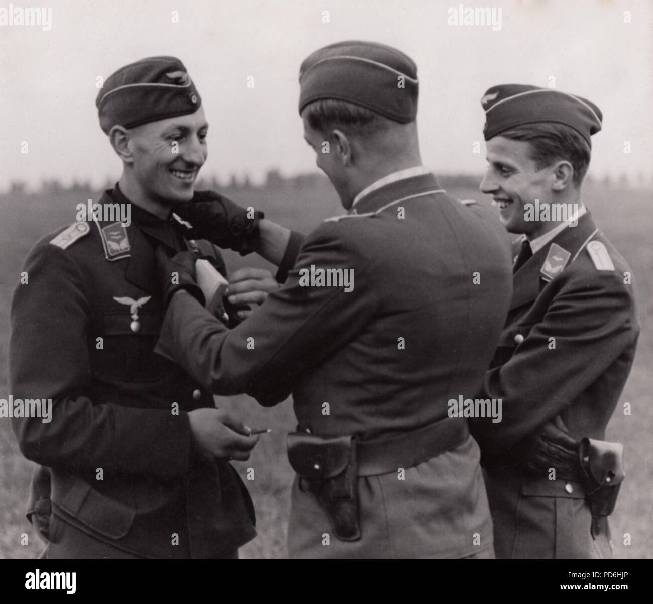 Bild aus dem Fotoalbum von Oberleutnant Oscar Müller von kampfgeschwader 1: In einem fröhlichen Moment, Oberleutnant Zeitler der 5./KG 1 sein eisernes Kreuz 1.Klasse bekommt am Flugplatz Rosiére, Frankreich, im September 1940. Die Präsentation von Officer ist Pinning die Auszeichnung auf Zeitler die Kehle durch, in der Position des Kreuzes des Ritter des Eisernen Kreuzes. Leutnant Oscar Müller ist auf der rechten Seite des Trios. Stockfoto