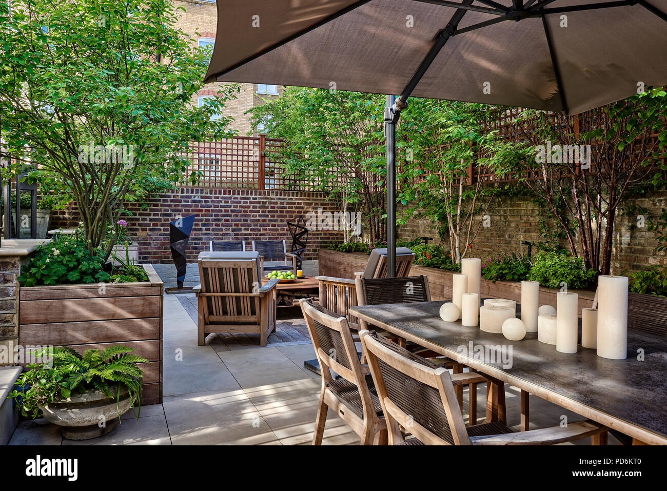 Sonnenschirm über Tisch mit Kerzen in Garten im Innenhof des viktorianischen London home Stockfoto