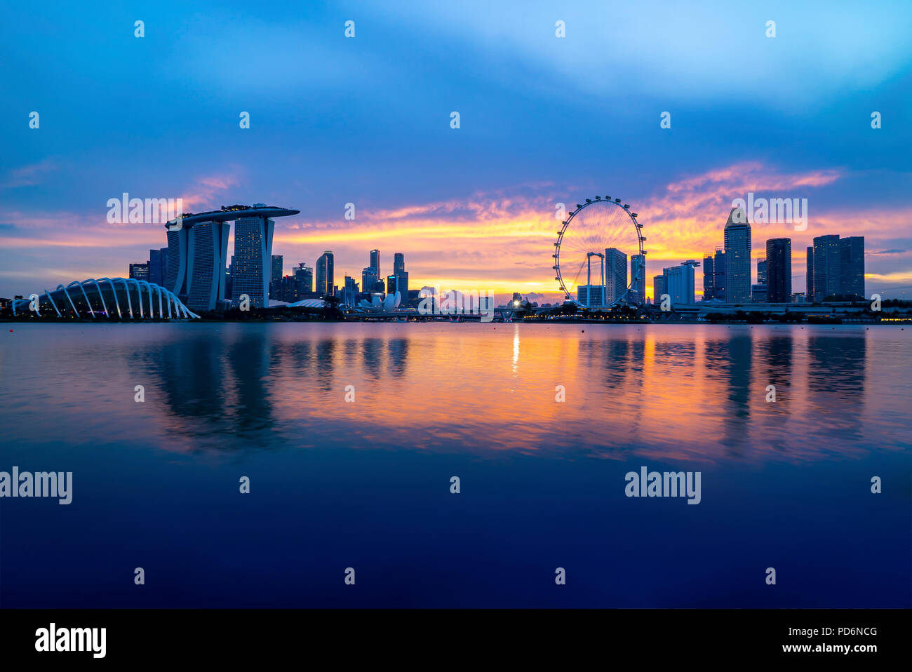 Singapur Wahrzeichen der Skyline der Stadt an der Marina Bay bei Sonnenuntergang Dämmerung. Stockfoto