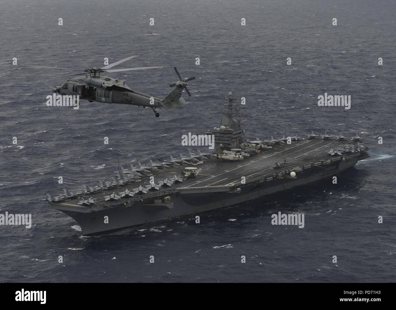 Ein MH-60S Sea Hawk Hubschrauber schwebt über dem Flugzeugträger USS Nimitz (CVN 68) während ein Foto Übung mit der indischen Marine und Japan Maritime Verteidigung-kraft während der Übung Malabar 2017. Stockfoto