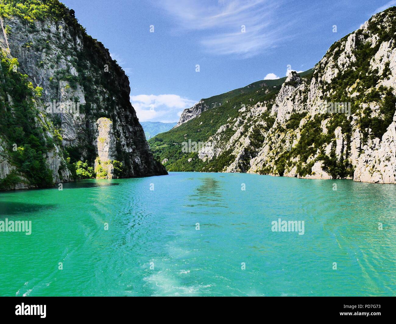 Hoher Kontrast verträumter Blick auf ruhige, türkisfarbene Wasser des künstlichen See Komani und steilen Seiten der Tal, Albanien, einladenden Abenteuer und Exploration Stockfoto